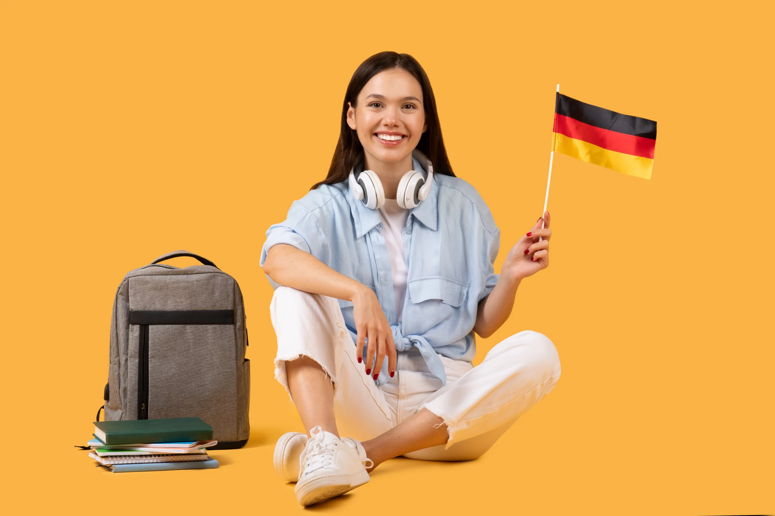 Almanya bayrağı tutan kulaklıklı genç kadın öğrenci